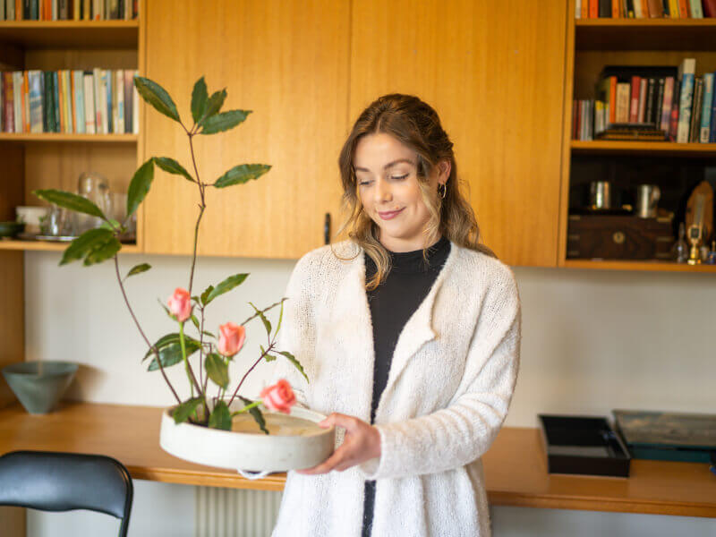 Woman holding up Ikebana arrangement